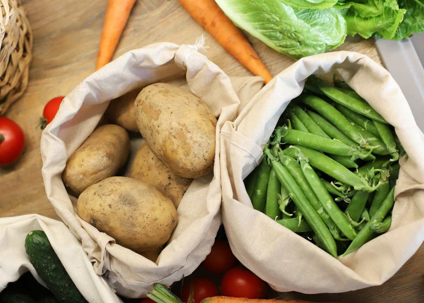 Cloth bags filled with fresh potatoes and green beans